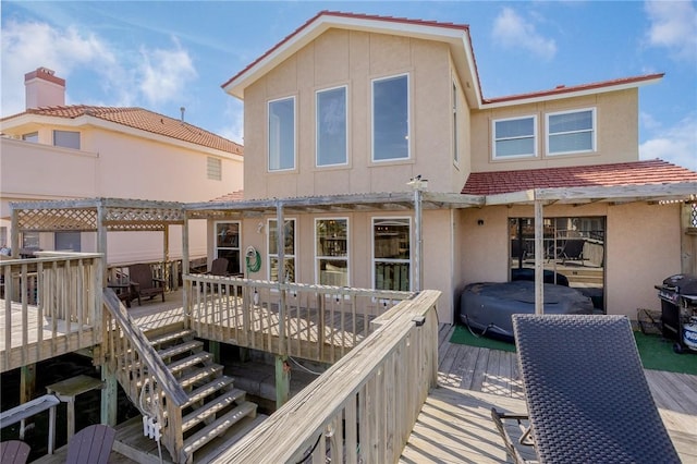 back of house featuring a wooden deck and stucco siding