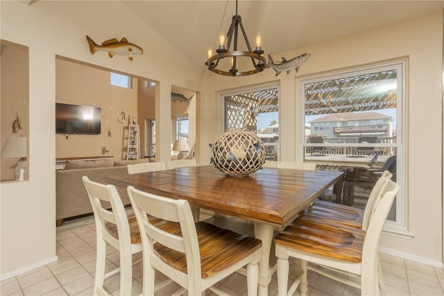 dining space featuring lofted ceiling, a notable chandelier, baseboards, and light tile patterned floors