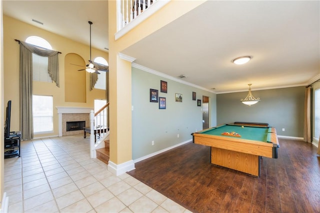 recreation room featuring ceiling fan, baseboards, tile patterned flooring, and ornamental molding