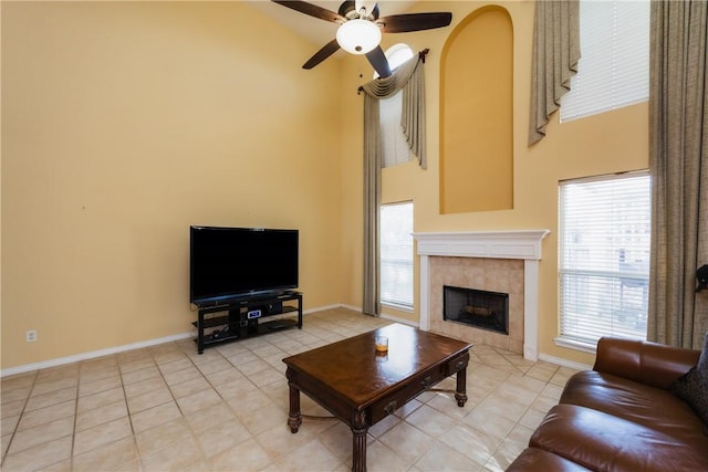 living area with a high ceiling, light tile patterned floors, and a fireplace