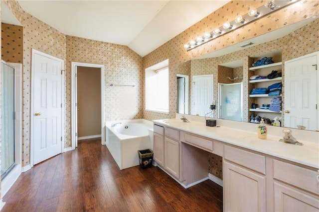 full bath with a sink, hardwood / wood-style flooring, a stall shower, and wallpapered walls