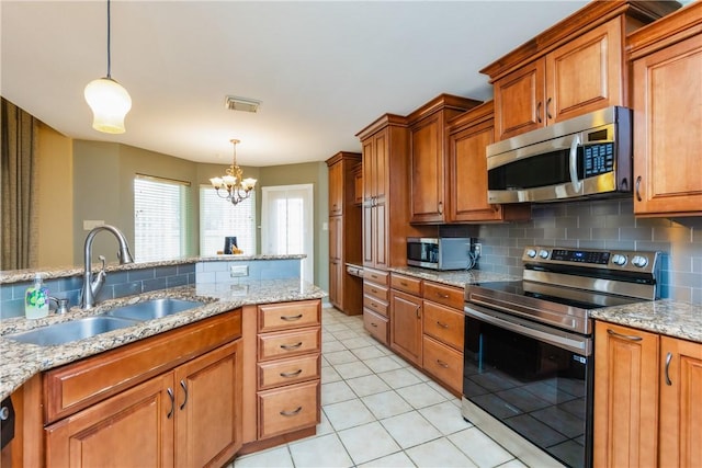 kitchen featuring backsplash, brown cabinetry, appliances with stainless steel finishes, and a sink