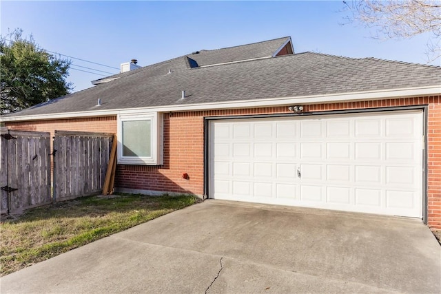 view of side of property with fence, brick siding, concrete driveway, and a shingled roof