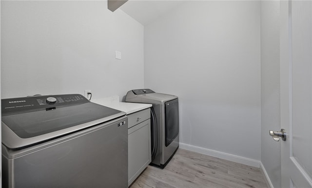 clothes washing area featuring independent washer and dryer and light hardwood / wood-style flooring