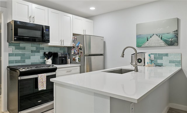 kitchen featuring black appliances, white cabinets, sink, tasteful backsplash, and kitchen peninsula