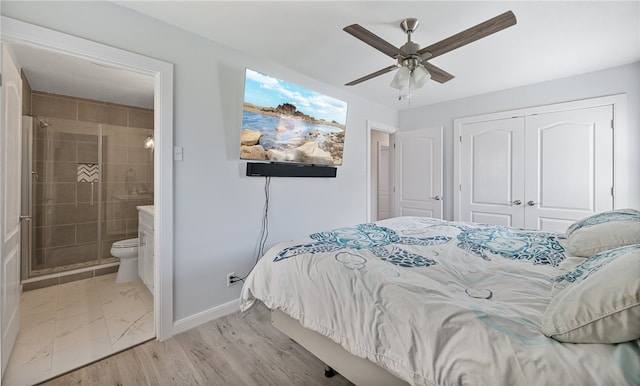 bedroom with ceiling fan, light hardwood / wood-style floors, ensuite bath, and a closet