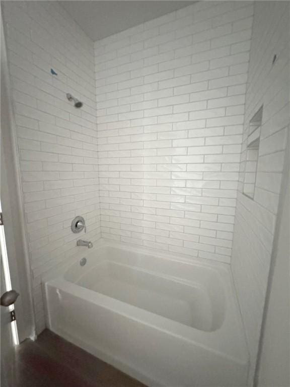 bathroom with tiled shower / bath combo and hardwood / wood-style floors