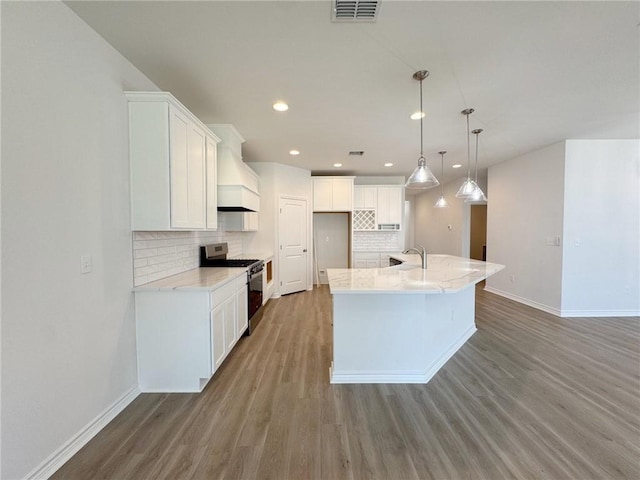 2550 Las Estrellas St, Corpus Christi, TX 78414 - kitchen with stainless steel range with gas cooktop, a sink, light wood-style floors, baseboards, and tasteful backsplash