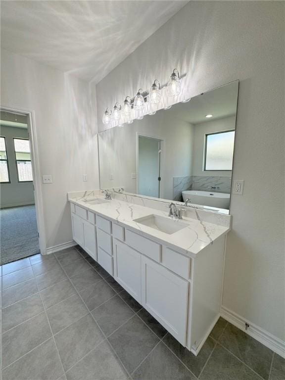 2550 Las Estrellas St, Corpus Christi, TX 78414 - bathroom with double vanity, a freestanding tub, tile patterned flooring, and baseboards
