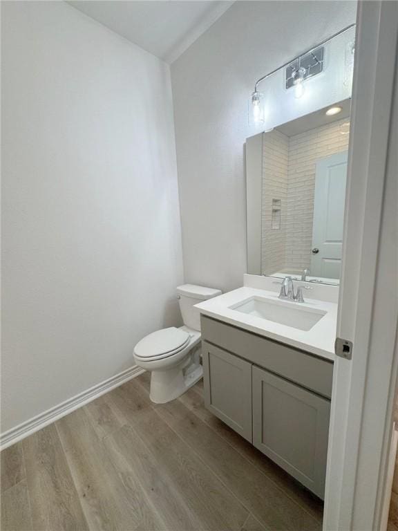 2550 Las Estrellas St, Corpus Christi, TX 78414 - bathroom with wood finished floors, toilet, vanity, and baseboards