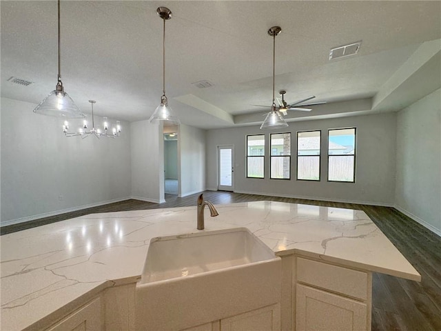 2550 Las Estrellas St, Corpus Christi, TX 78414 - kitchen featuring open floor plan, dark wood-style flooring, light stone counters, and hanging light fixtures