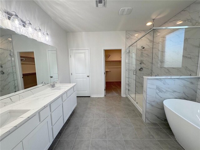 2550 Las Estrellas St, Corpus Christi, TX 78414 - bathroom featuring double vanity, a marble finish shower, a spacious closet, and a freestanding tub