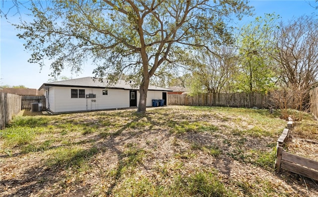 view of yard with central air condition unit and a fenced backyard