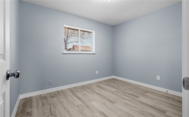 unfurnished room featuring baseboards and wood finished floors