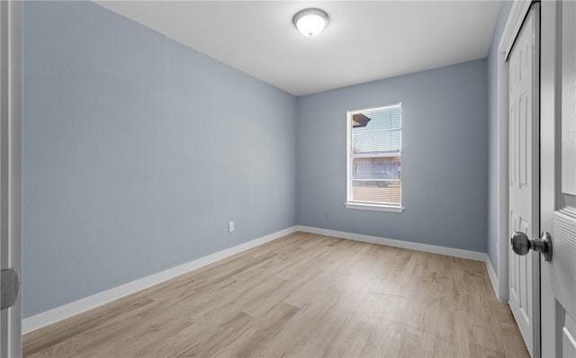 unfurnished bedroom with light wood-style floors, baseboards, and a closet