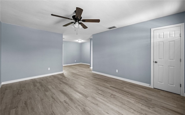 empty room featuring a ceiling fan, baseboards, and wood finished floors