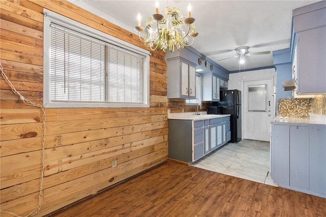 3718 Brushwood, Corpus Christi, TX 78415 - kitchen featuring light countertops, freestanding refrigerator, wooden walls, a chandelier, and gray cabinets