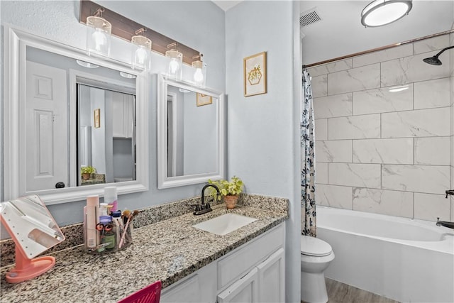 full bath with toilet, shower / tub combo, wood finished floors, visible vents, and vanity