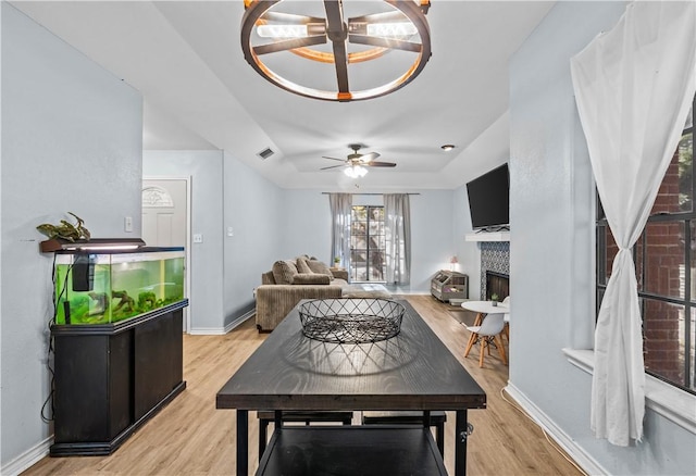 living room with visible vents, a fireplace, light wood-style flooring, and baseboards