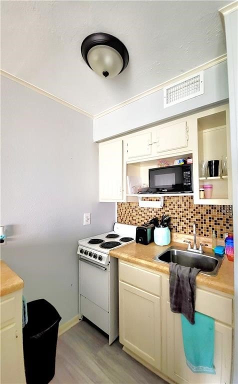 kitchen with light wood-type flooring, sink, tasteful backsplash, and white stove