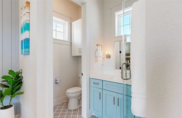 bathroom featuring walk in shower, vanity, and toilet