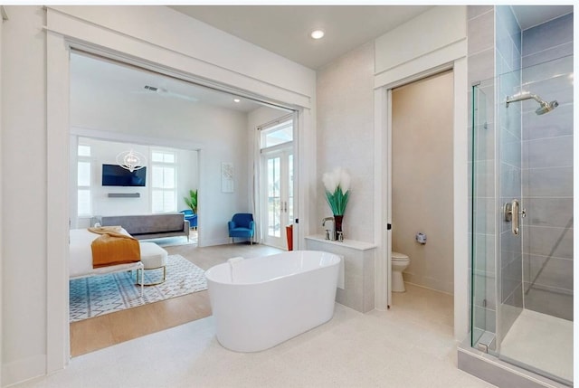 bathroom featuring hardwood / wood-style floors, toilet, and plus walk in shower