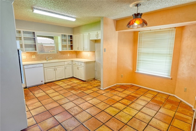 4513 Greensboro Dr, Corpus Christi, TX 78413 - kitchen with white dishwasher, white cabinets, light countertops, decorative light fixtures, and a textured ceiling