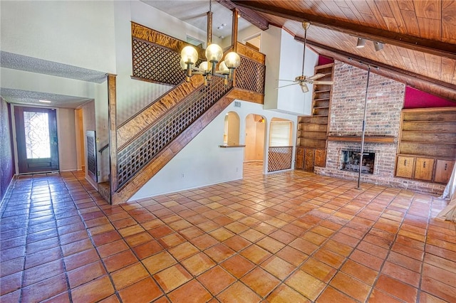 4513 Greensboro Dr, Corpus Christi, TX 78413 - unfurnished living room with high vaulted ceiling, a fireplace, stairway, a chandelier, and a ceiling fan