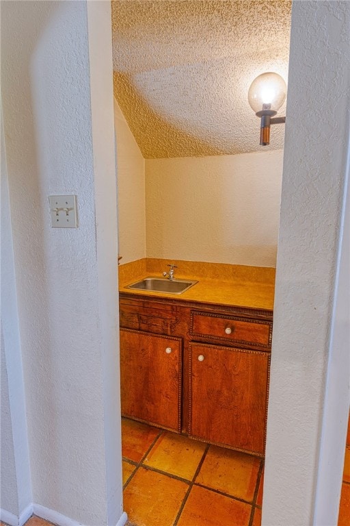 4513 Greensboro Dr, Corpus Christi, TX 78413 - bathroom featuring a textured wall, vaulted ceiling, a textured ceiling, and vanity