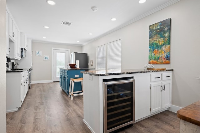 kitchen with wine cooler, white cabinetry, stainless steel appliances, and blue cabinets