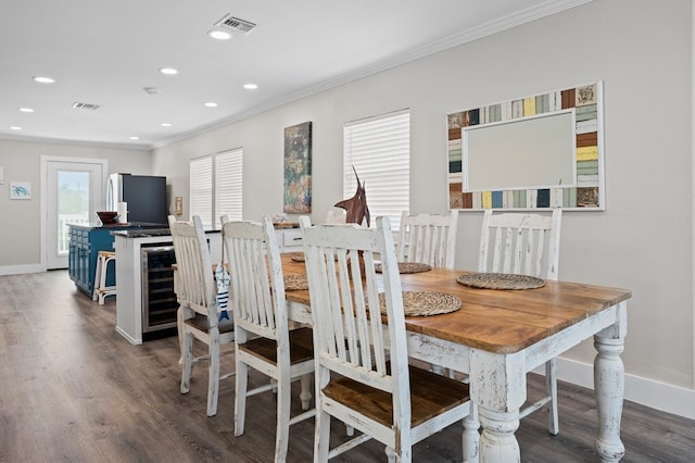 dining space with dark wood-type flooring, a healthy amount of sunlight, and ornamental molding