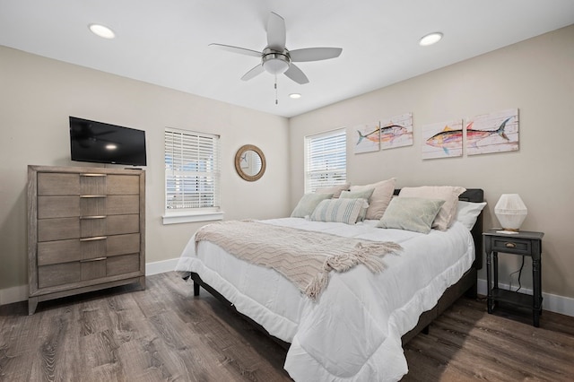 bedroom featuring ceiling fan, dark wood-type flooring, and multiple windows