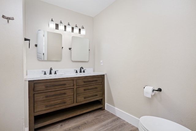 bathroom with vanity, wood-type flooring, and toilet