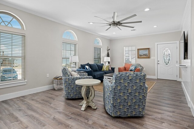 living room featuring ceiling fan, ornamental molding, and hardwood / wood-style flooring