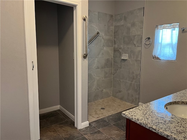 bathroom with vanity and a tile shower