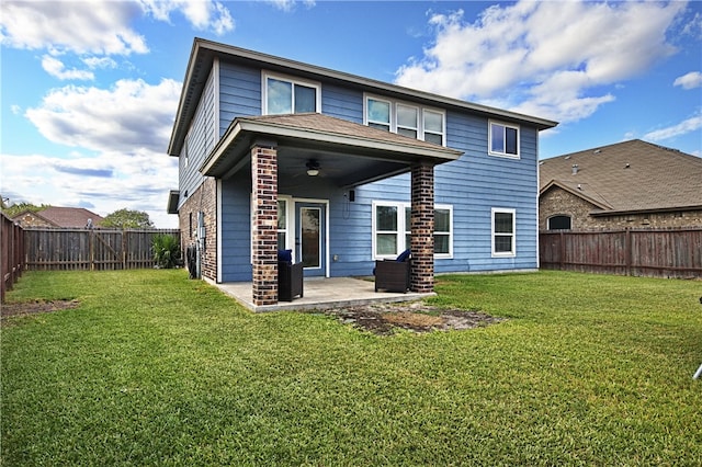 back of property featuring ceiling fan, a lawn, and a patio area