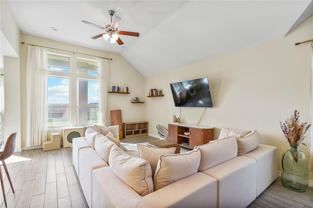 living room with ceiling fan, light hardwood / wood-style floors, and lofted ceiling