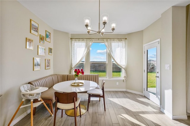 dining room featuring breakfast area, light hardwood / wood-style floors, and a notable chandelier