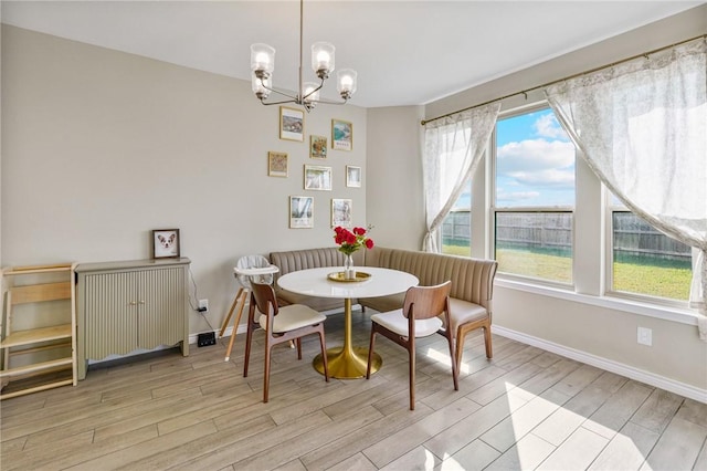 dining area featuring breakfast area, light hardwood / wood-style floors, a wealth of natural light, and a notable chandelier