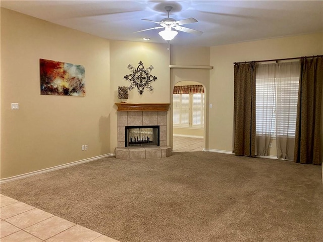 unfurnished living room featuring tile patterned flooring, a ceiling fan, carpet flooring, and a tile fireplace