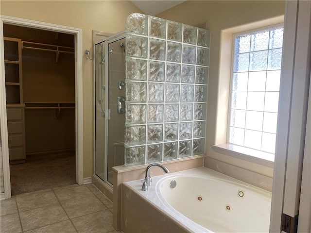 bathroom with tile patterned flooring, a jetted tub, a spacious closet, and a stall shower