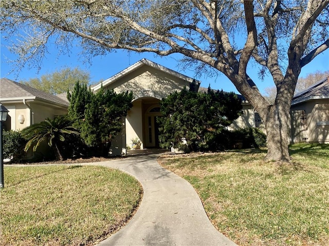 view of front of house featuring stucco siding and a front yard