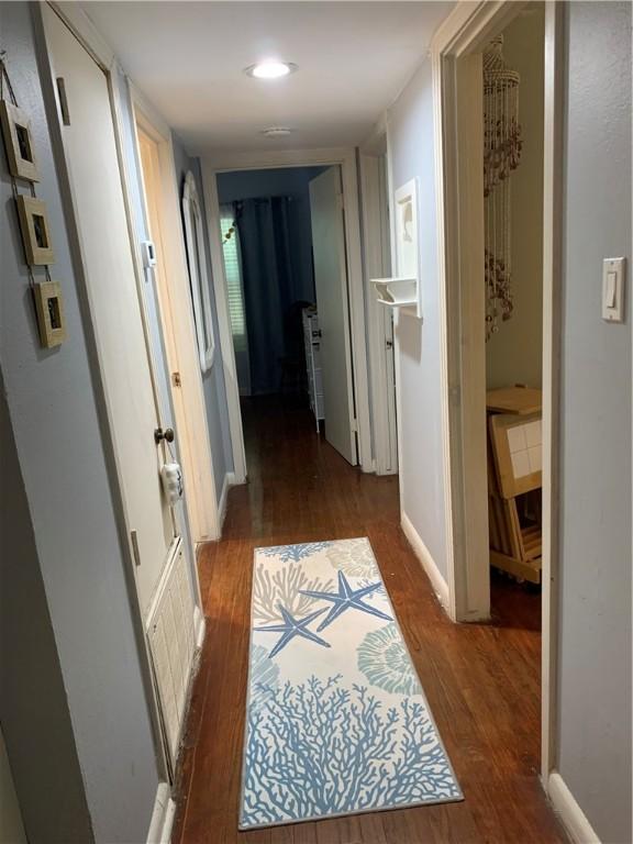 corridor featuring wood finished floors and recessed lighting