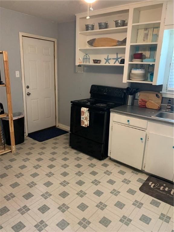kitchen with black electric range, open shelves, white cabinetry, and dark countertops