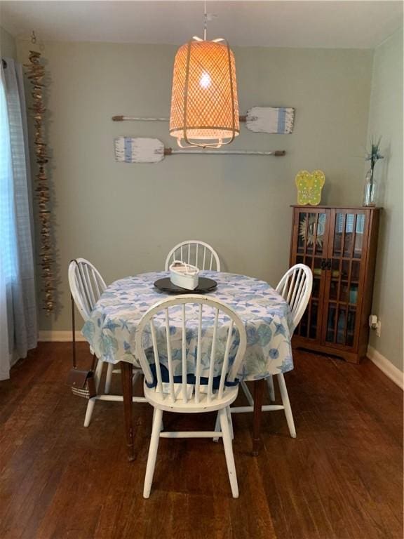 dining space featuring wood finished floors and baseboards