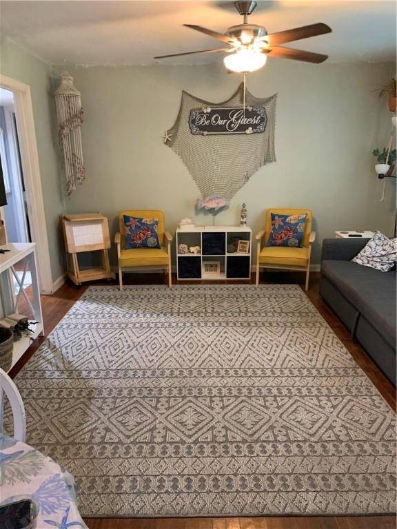 living area featuring wood finished floors and a ceiling fan