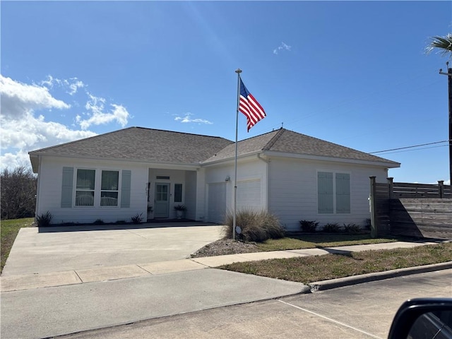 single story home with concrete driveway, fence, a garage, and a shingled roof