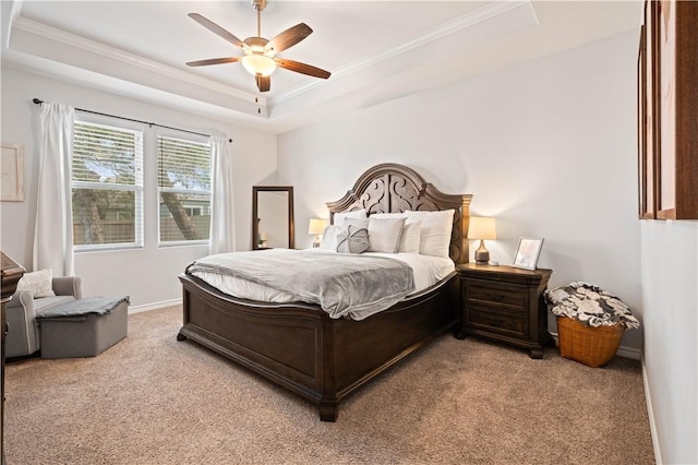 bedroom featuring a raised ceiling, light colored carpet, ornamental molding, ceiling fan, and baseboards