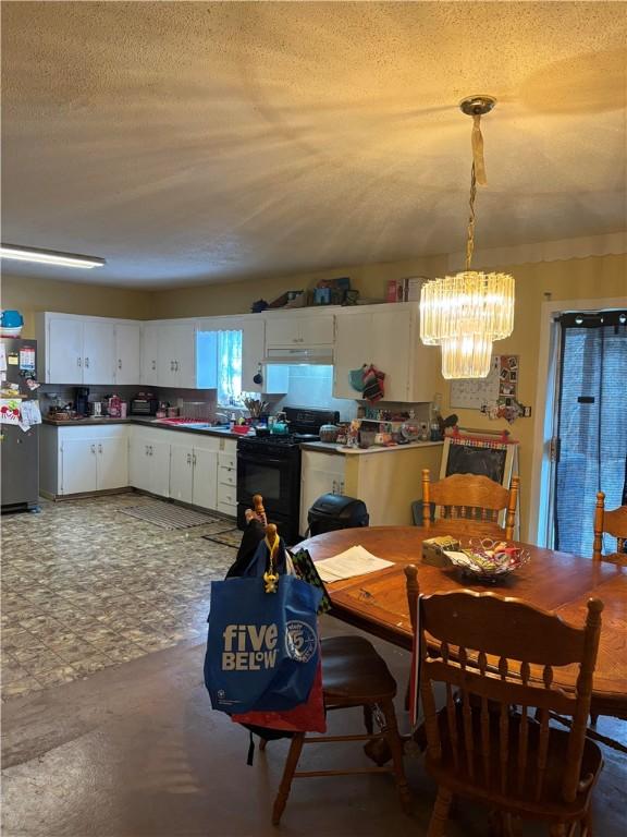 dining space with a chandelier and a textured ceiling