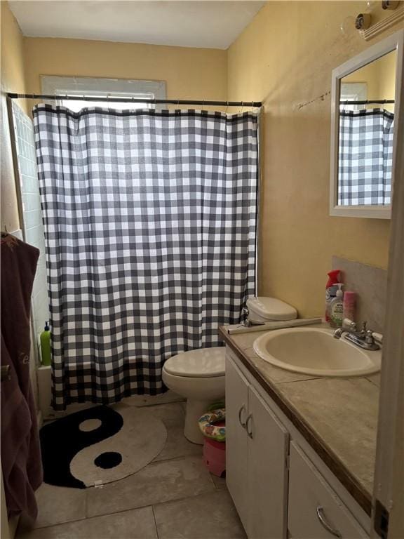 full bathroom with shower / bath combo with shower curtain, tile patterned floors, toilet, and vanity